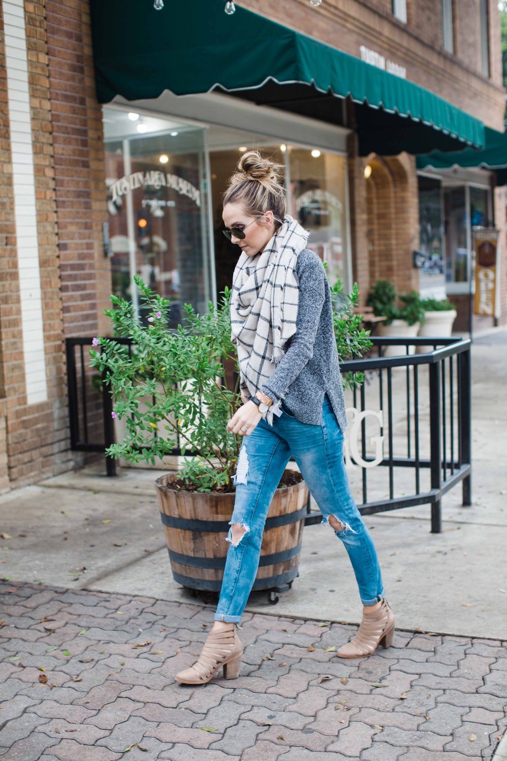 gray sweater, blue jeans, and blanket scarf
