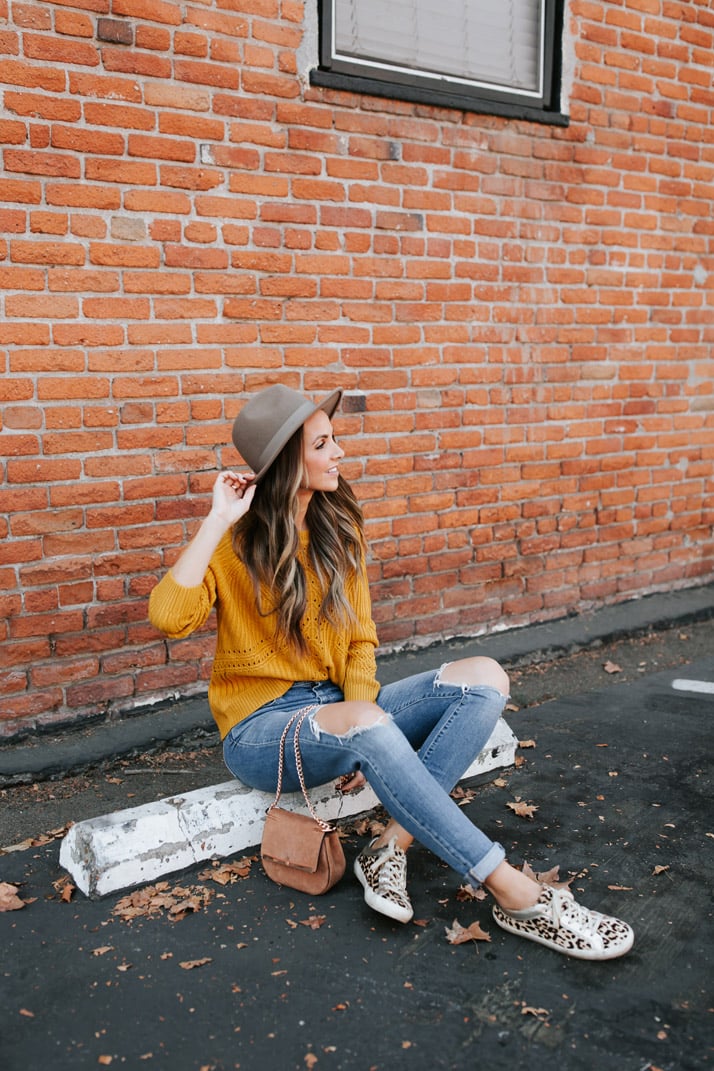 mustard yellow sweater and leopard sneakers