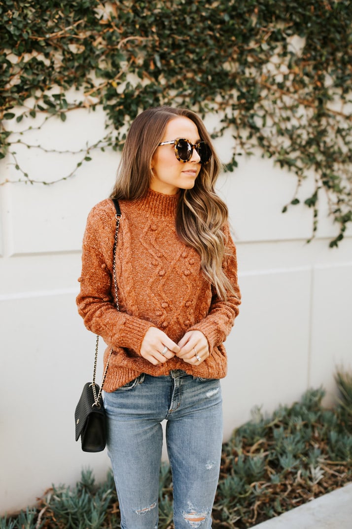 rust mock neck sweater and light wash jeans