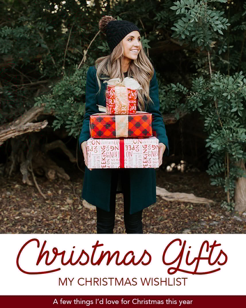 woman in black pom pom hat with stack of Christmas presents