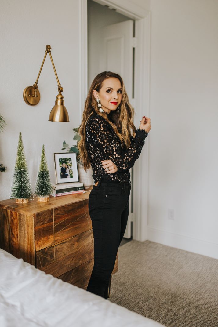 merrick in master bedroom with black jeans black lace top and red lipstick