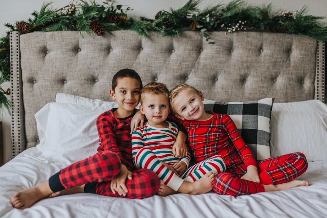 boys in christmas pajamas on the bed