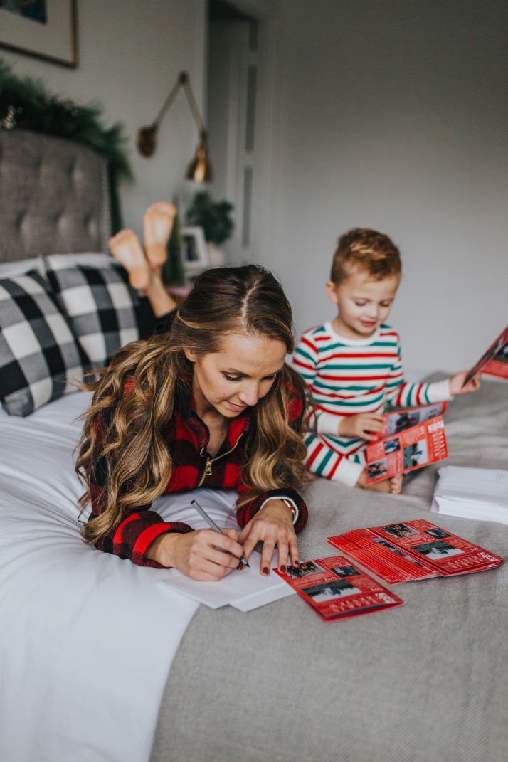 mom and son on bed prepping holiday cards