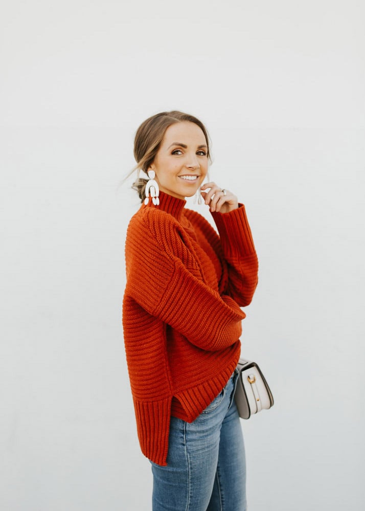 women in red sweater with arm folded